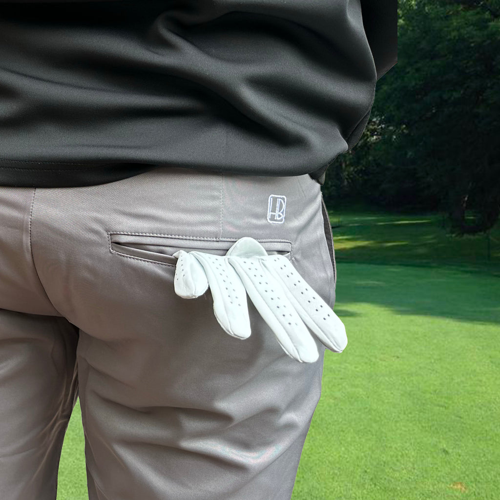 Hole Black Golf mannequin portant un bermuda de golf gris avec un gant de golf dans la poche arrière et un pull de golf noir