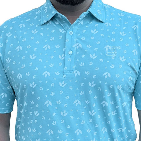 Mannequin portant un polo de golf bleu ciel Hole Black imprimé fleurs blanches aqua de face