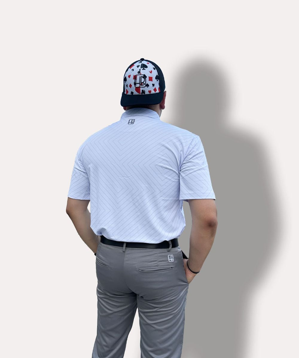 Hole Black Golf mannequin portant un pantalon de golf gris, une casquette noire et un polo de golf blanc imprimé