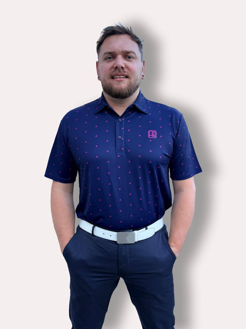 Mannequin portant un polo de golf bleu violet Hole Black imprimé triangles roses de face avec pantalon de golf marine