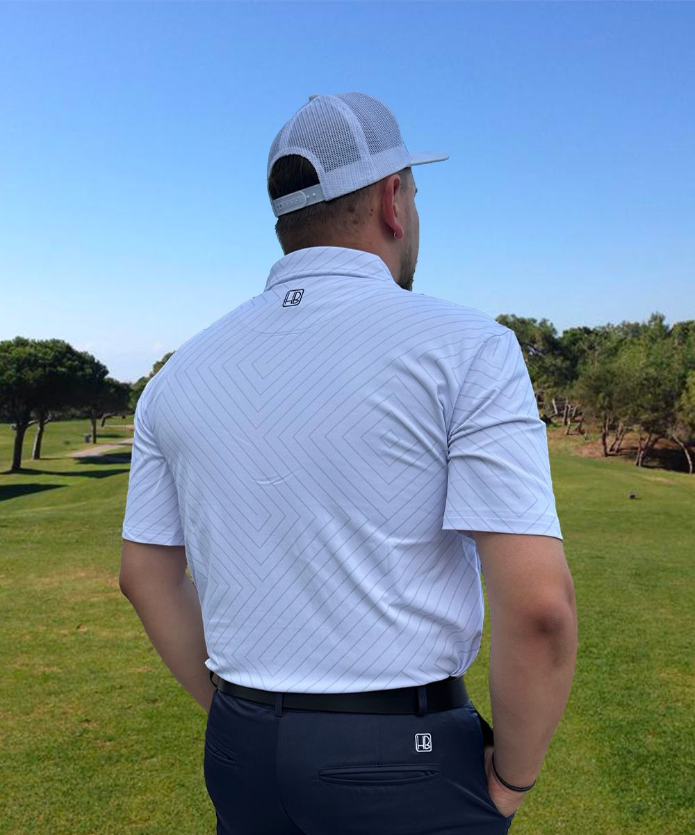 Hole Black Golf mannequin portant un pantalon de golf marine et un polo de golf blanc 