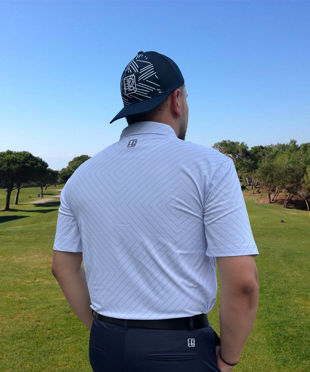Hole Black Golf mannequin portant un polo de golf blanc imprimé, un pantalon de golf marine et une casquette golf bleue