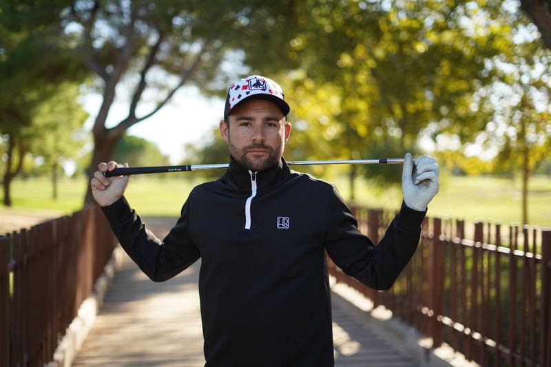 Joueur de golf portant un pull Hole Black noir, sweat avec zip fermeture eclair 1/4 extensible pour l'hiver, jouer au chaud