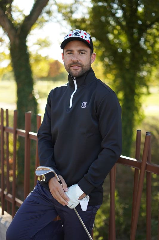 Joueur de golf portant un pull Hole Black noir de côté, sweat avec zip fermeture eclair 1/4 extensible pour l'hiver, jouer au chaud